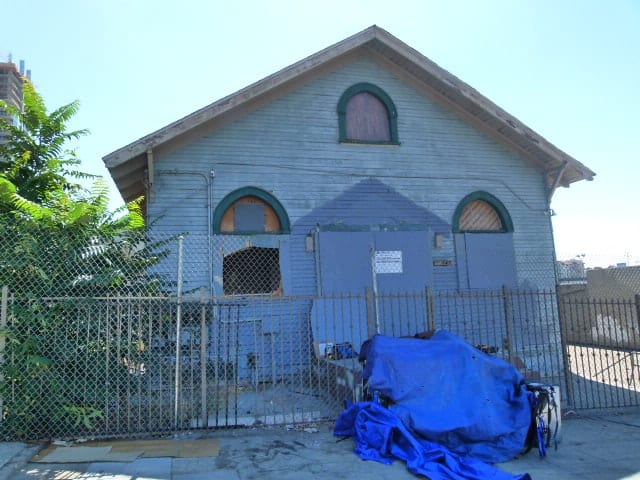 East Village Church before restoration — front facade with chain-link fence, 2014
